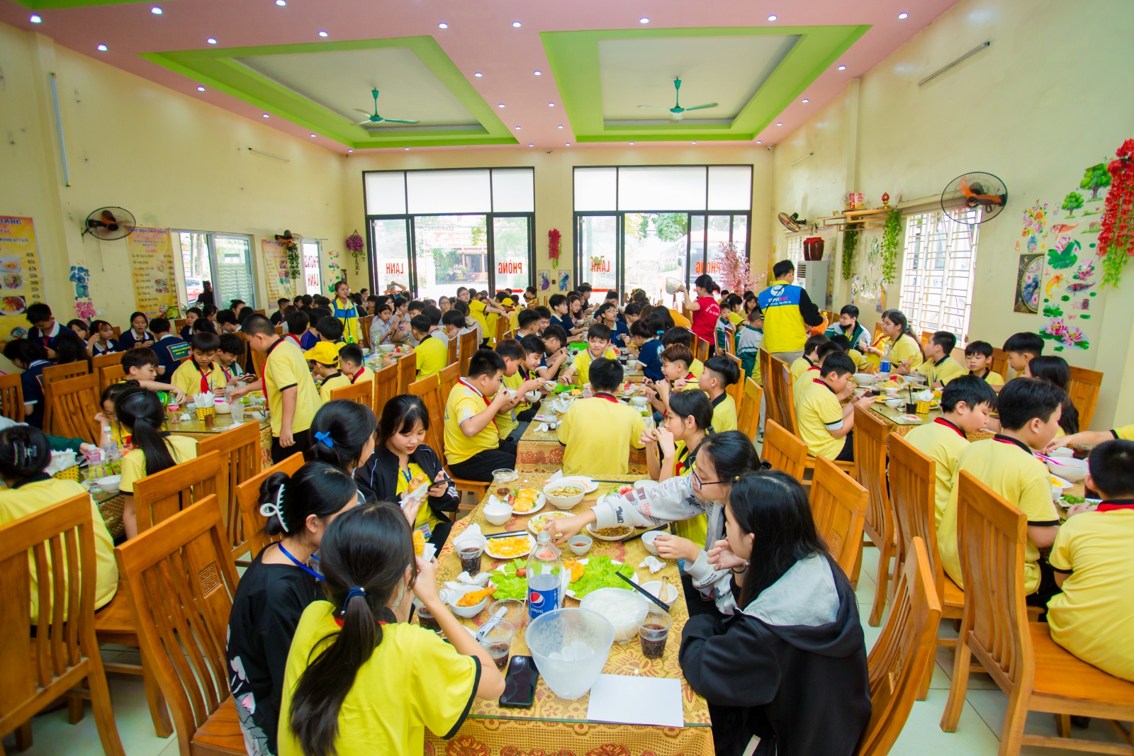 Học sinh với bữa trưa vui vẻ và ngon miệng tại nhà hàng.