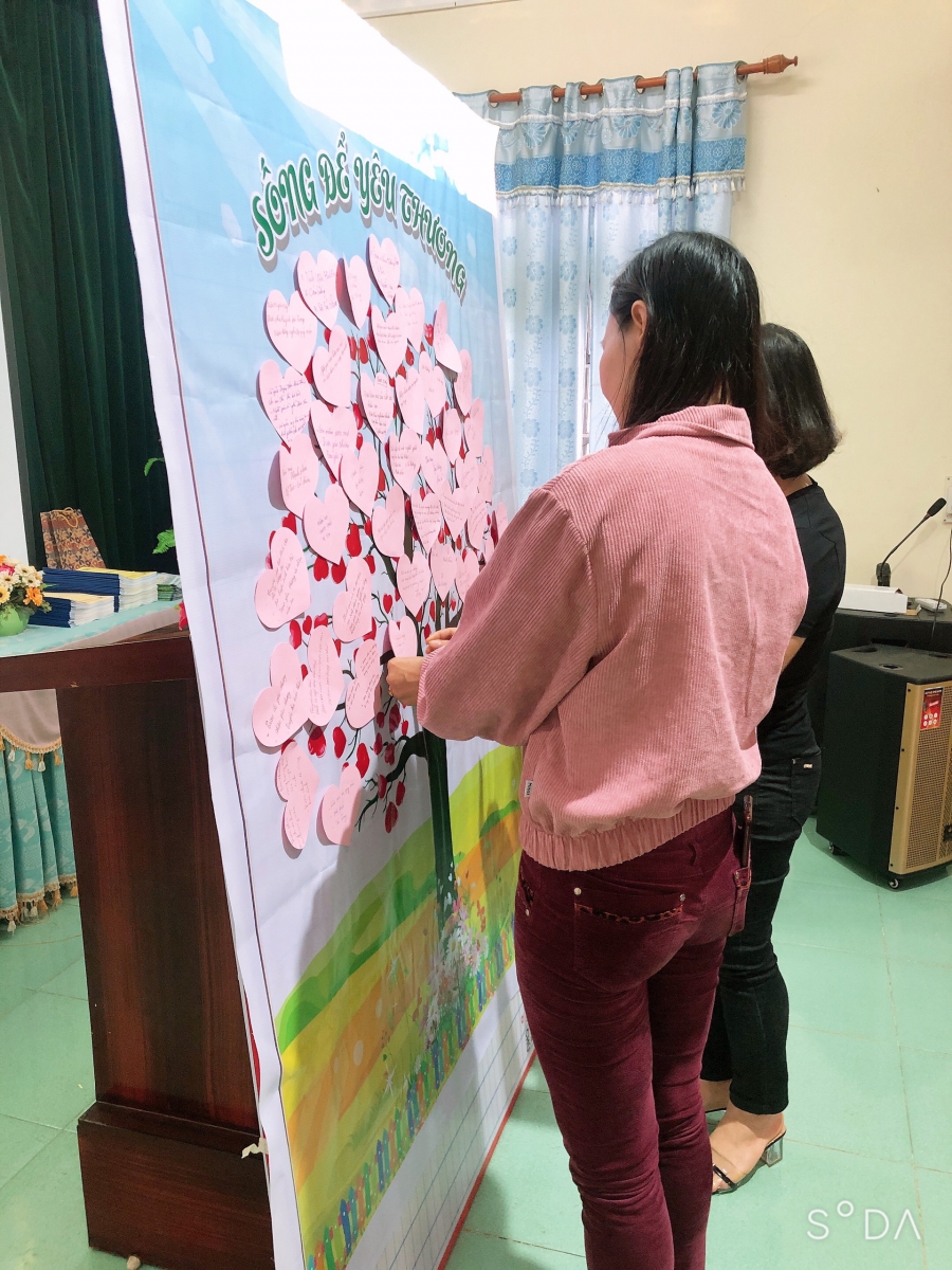 Các cô đang gắn những trái tim yêu thương lên cây yêu thương.