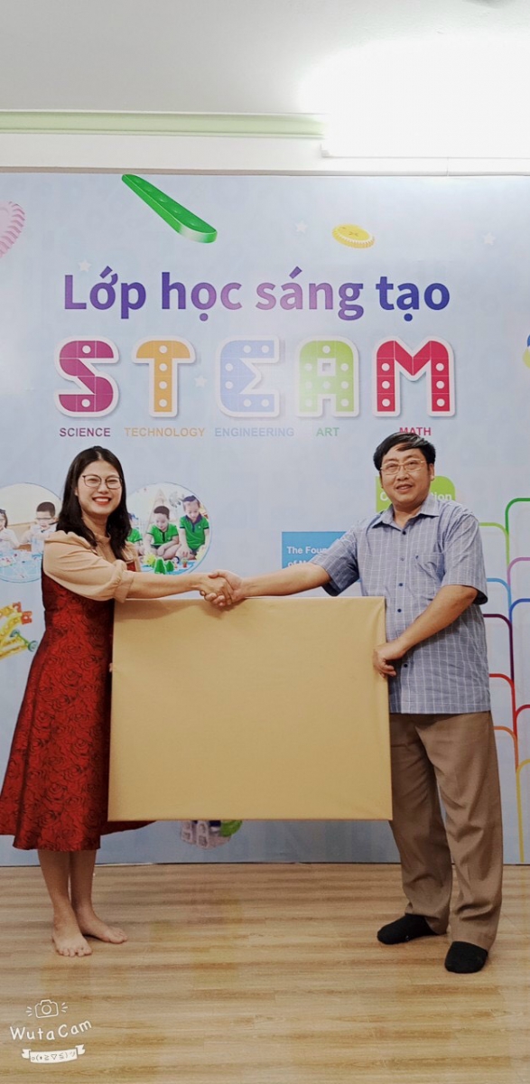 Thầy hiệu trưởng Nguyễn Đức Long trao tặng món quà lưu niệm cho trung tâm.