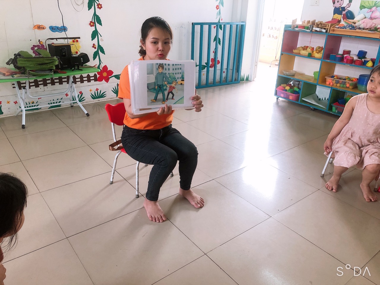 Cô Misa đang cho các bạn xem tranh để phân biệt người lạ mặt tốt và người lạ mặt xấu