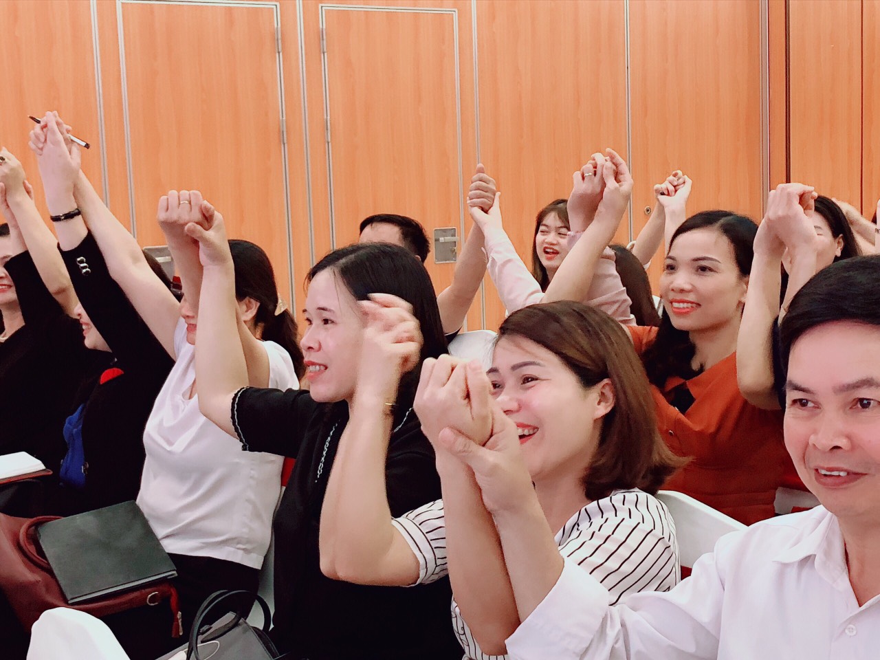 Các thầy cô đang chơi trò chơi khởi động nắm/ bắt tay/ vỗ tay nhau.