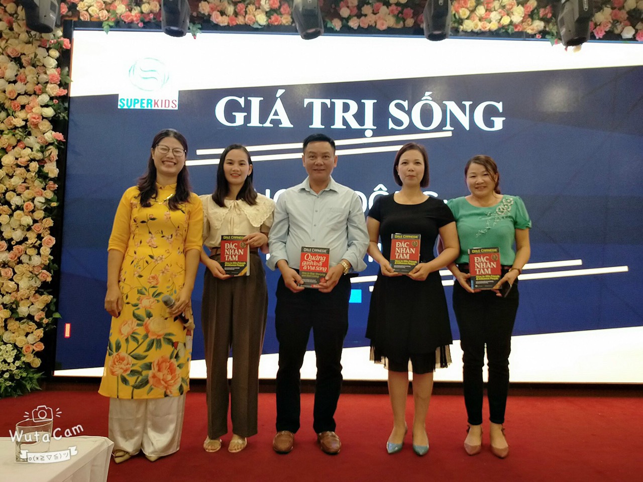 Các thầy tham gia trải nghiệm hứng nước, mở nắp chai lên nhận quà.