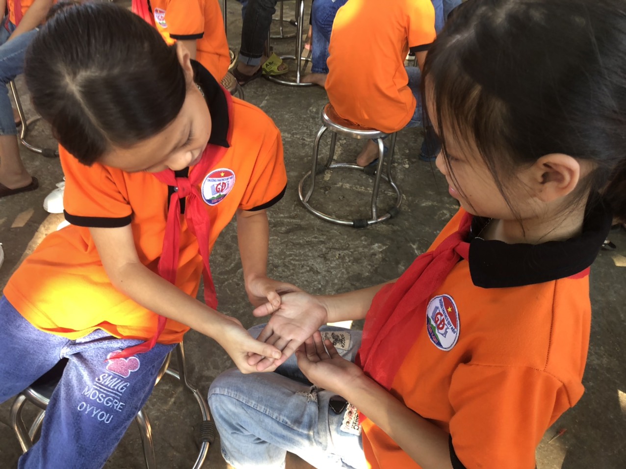 Hai bạn nhỏ ngồi cạnh nhau và thảo luận và bình chọn đôi bàn tay, các bạn đưa ra các tiêu chí về đôi bàn tay đẹp.