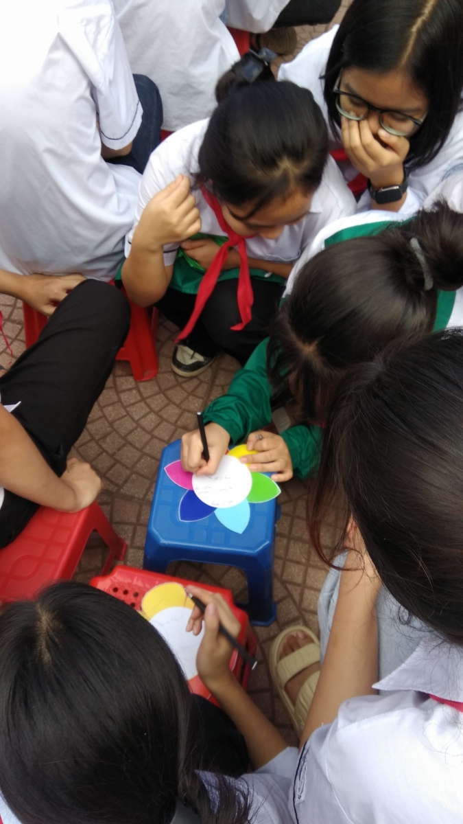 Các em học sinh đang thực hiện viết những lời yêu thương qua bông hoa lời nói