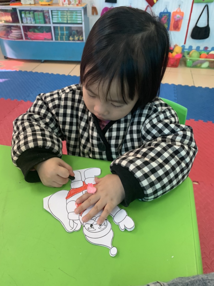 Học sinh lớp 3 tuổi A đang thực hiện tô màu cho bức tranh ông già Noel của mình.