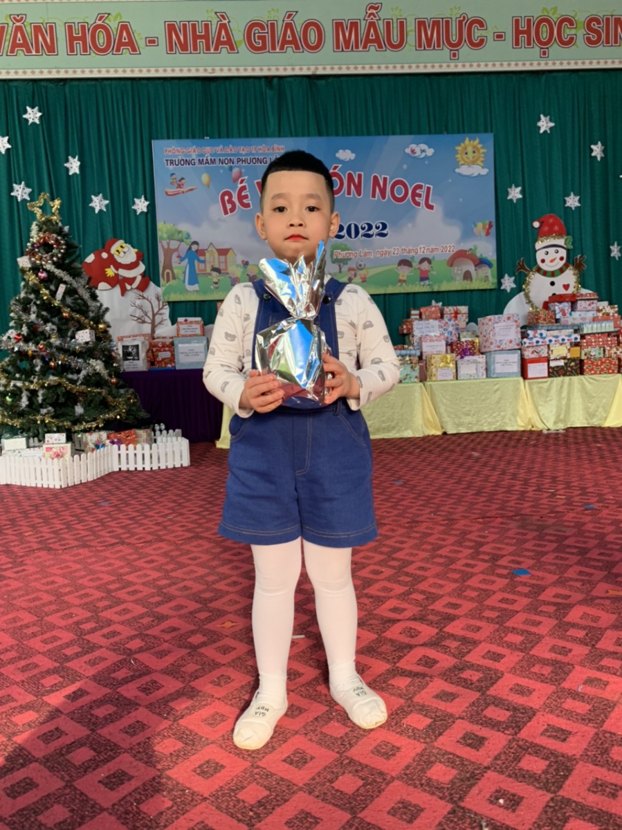 Hình ảnh bé trai vui vẻ trước phần quà từ trò chơi của ban tổ chức