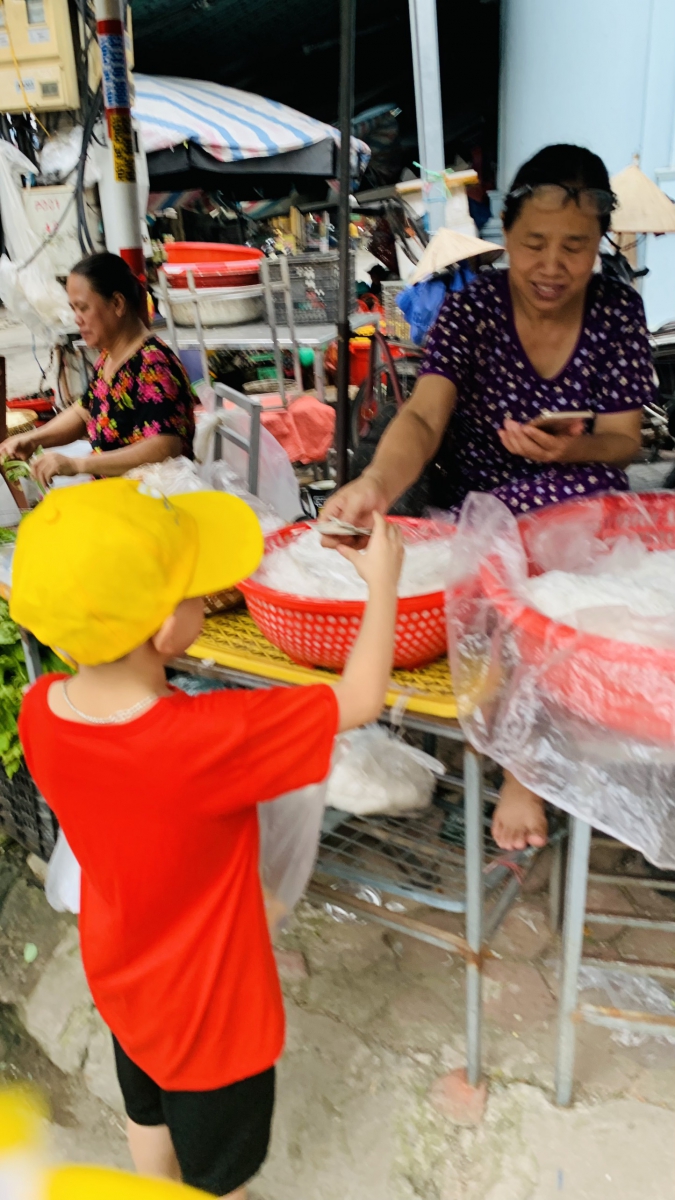 Học sinh bán hàng cho các cô chú bán hàng trong chợ.