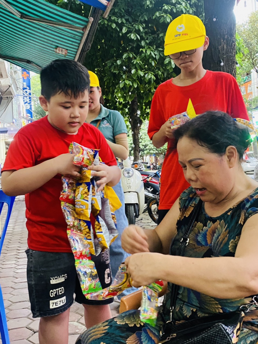 Hình ảnh người dân xung quanh mua hàng ủng hộ cho các em học sinh.